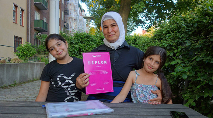 Glädje över diplom för avslutad svenskundervisning på Rosa Stationen. Foto: Matt Alesevich